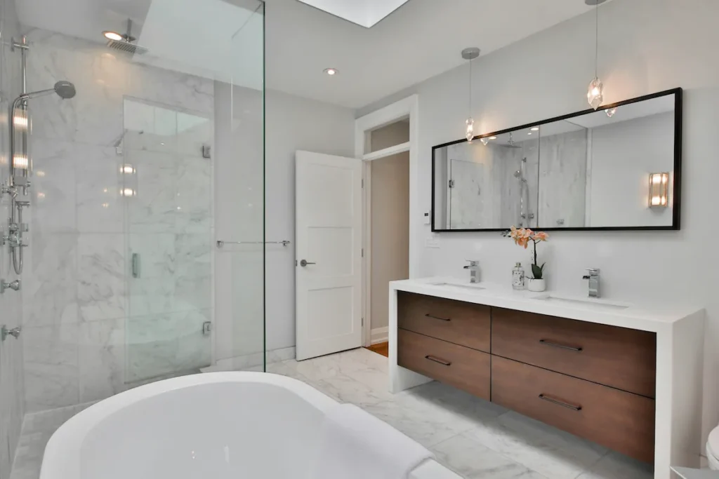 Complete bathroom renovation in Burlington with freestanding tub, glass shower, and wood vanity