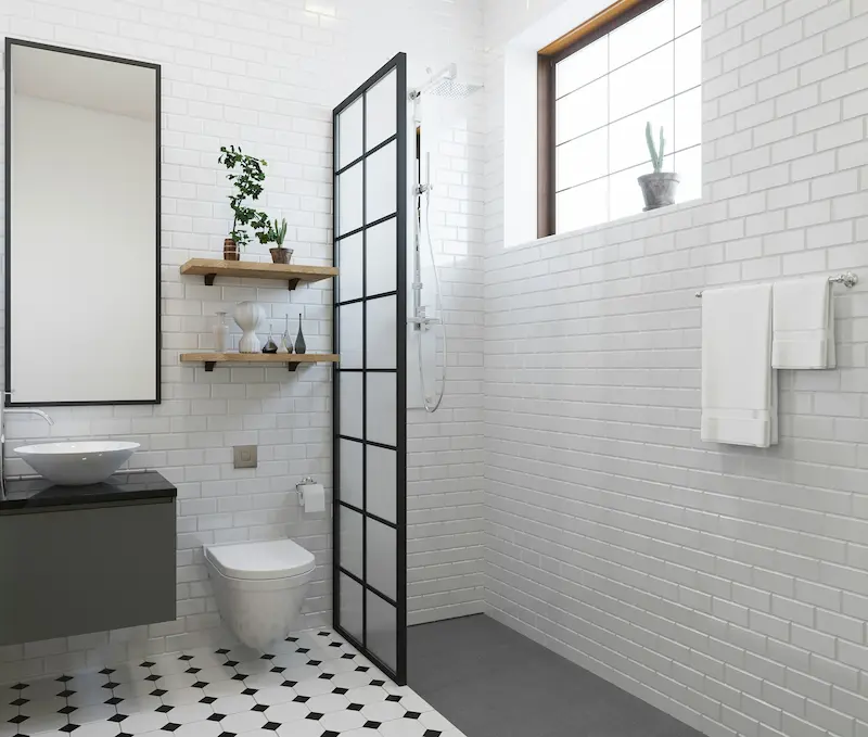 Custom walk-in shower with black-framed glass door and white subway tile in a Burlington bathroom