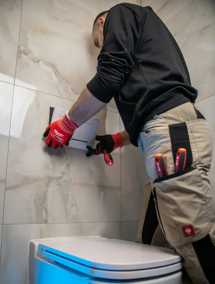 Skilled plumber installing a toilet during a bathroom renovation in Burlington