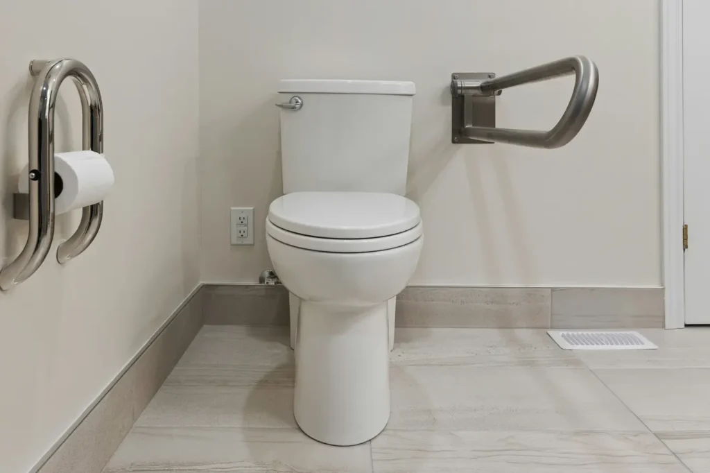Bathroom with fold-down stainless steel grab bars installed on both sides of the toilet