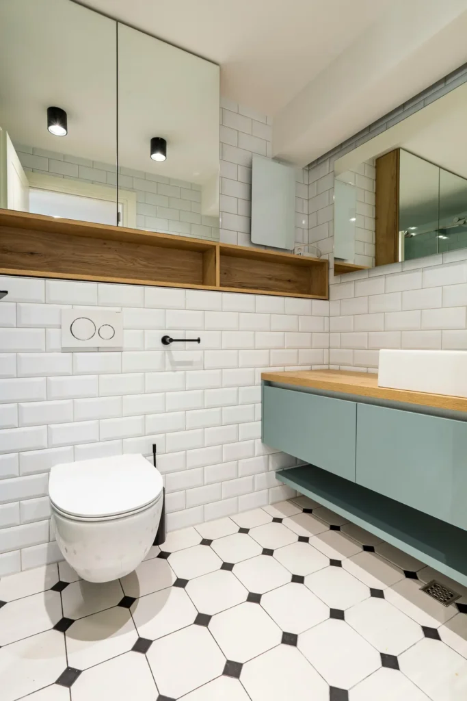 White subway wall tile and black-and-white patterned floor tile in a renovated bathroom