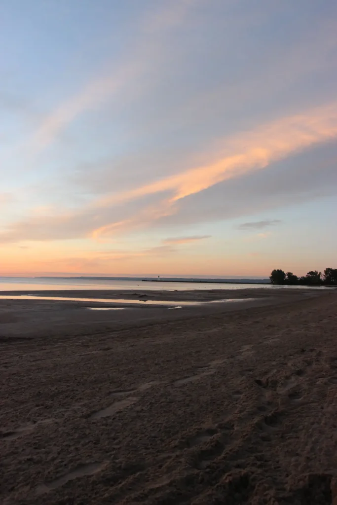 Sunrise over Burlington Beach with sandy shoreline and colorful skies in Burlington, Ontario