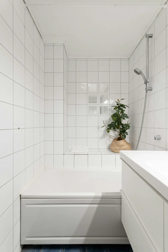 Finished white bathroom tile installation in Burlington with tiled tub-shower combo and clean minimalist finish