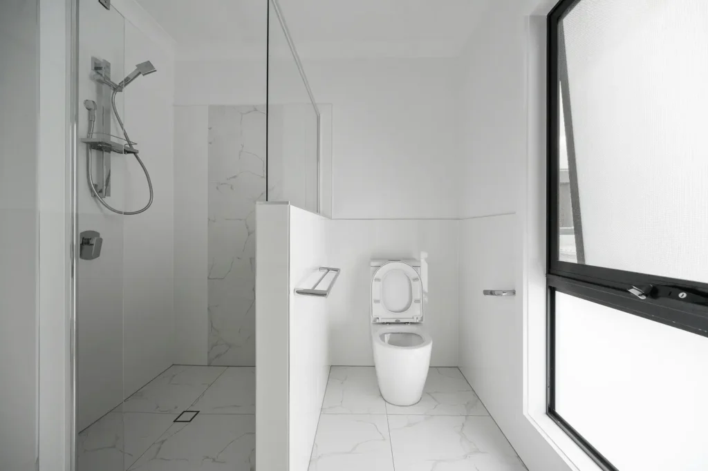 Curbless walk-in shower with a floor-level drain and glass divider in an accessible Burlington bathroom