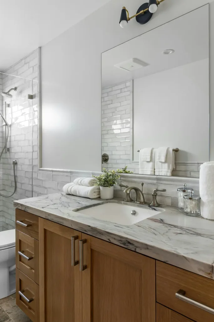 Custom-built wood bathroom vanity with marble countertop and modern fixtures in Burlington