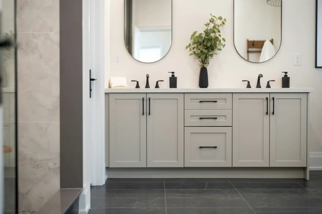 Double vanity with oval mirrors and black hardware in Burlington
