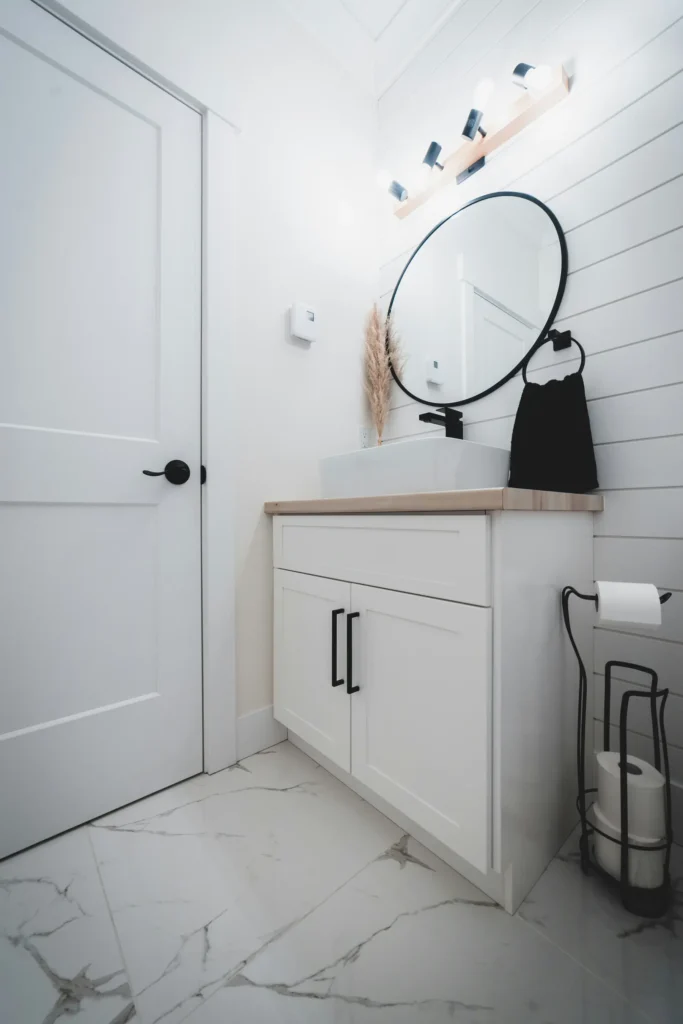 Freestanding white bathroom vanity with round mirror in Burlington