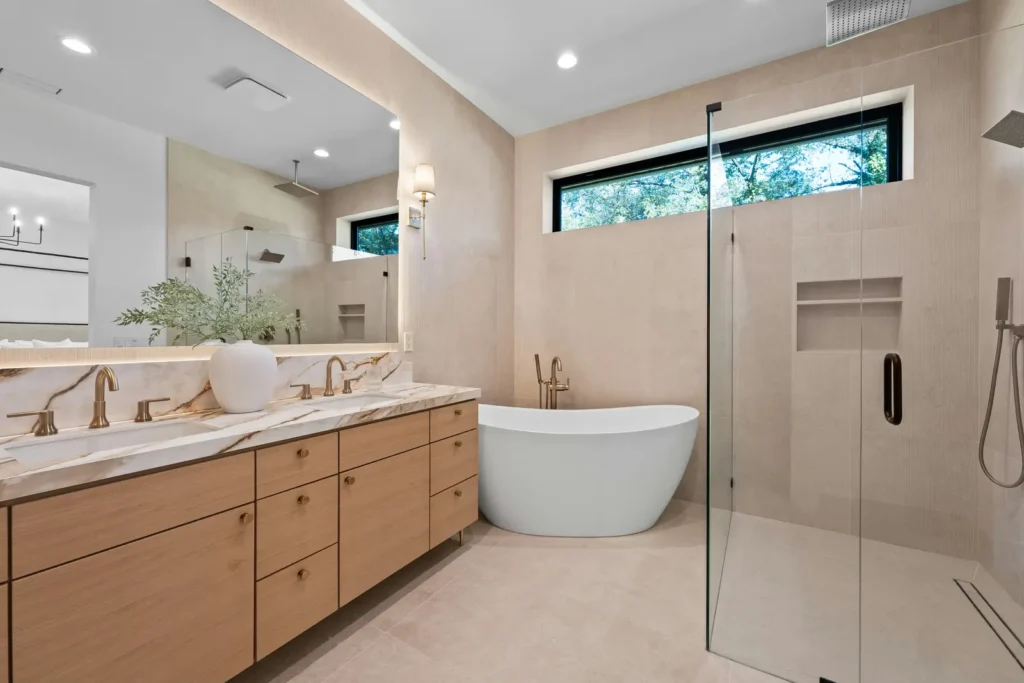 Modern full bathroom renovation with a wood double vanity, freestanding tub, and walk-in glass shower