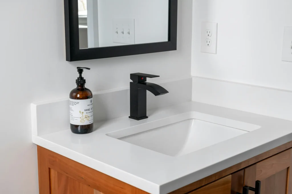 Quartz countertop bathroom vanity with black hardware and fixtures in Burlington