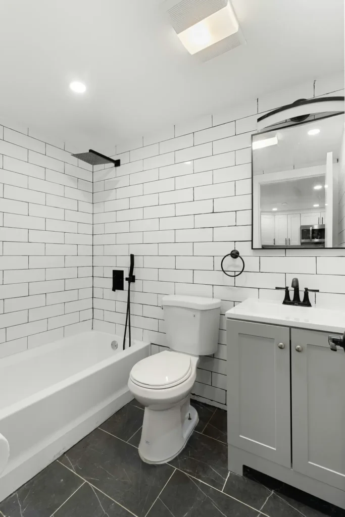 Tile and flooring renovation in Headon Forest, Burlington with white subway tile tub/shower surround and dark herringbone slate floor tile